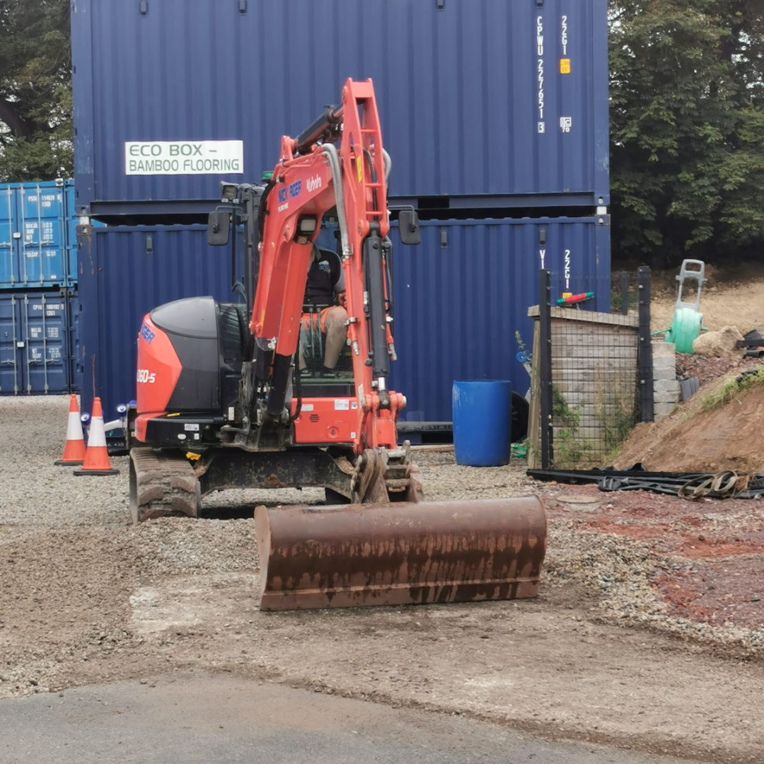 6-tonne-digger A DAF XG truck belonging to Nick Ager Haulage is parked on a gravel surface with a trailer loaded with raw materials. In the background, a small excavator and storage items are visible.