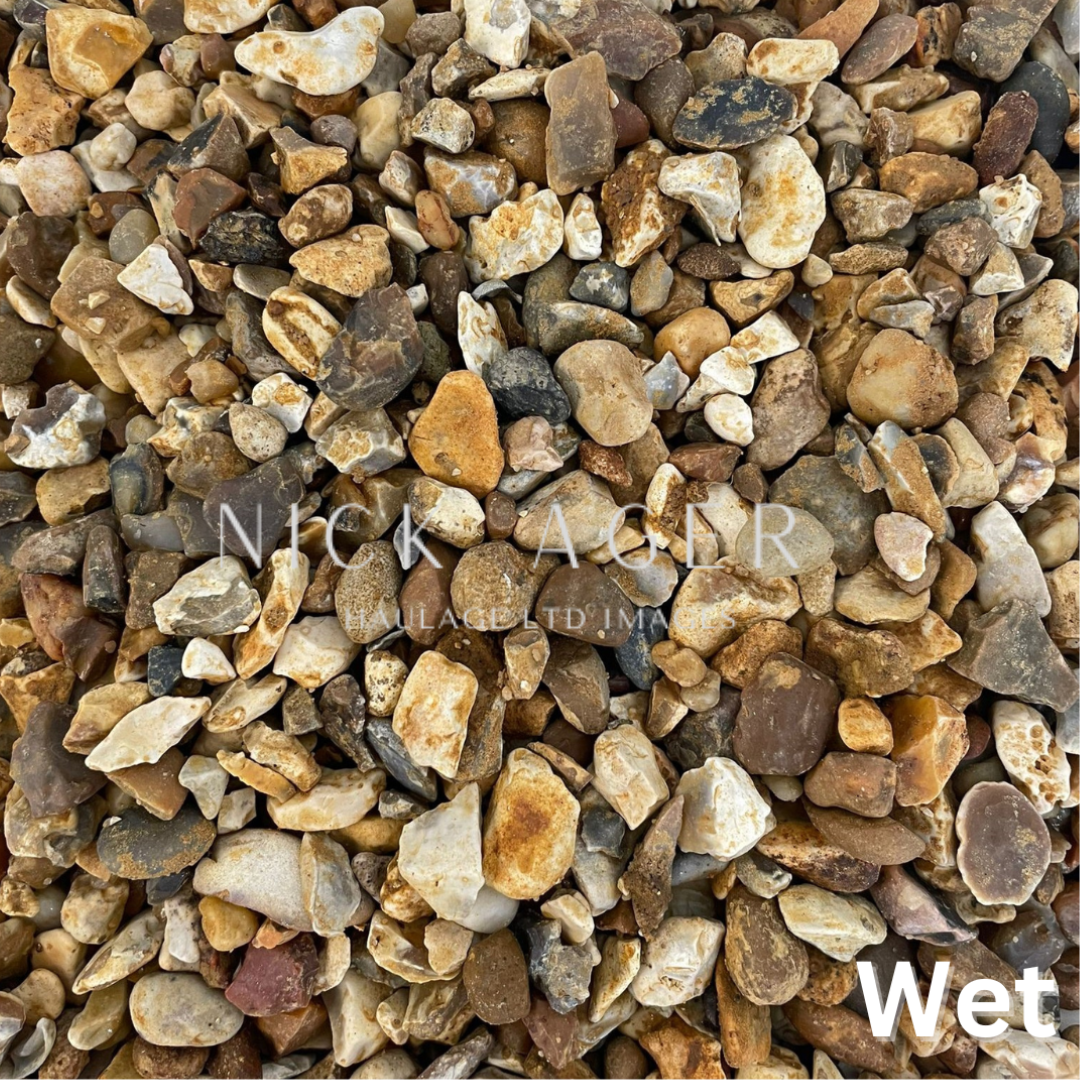 Close-up view of wet gravel stones in various earthy tones including brown, grey, and white, showcasing their natural texture and shape.