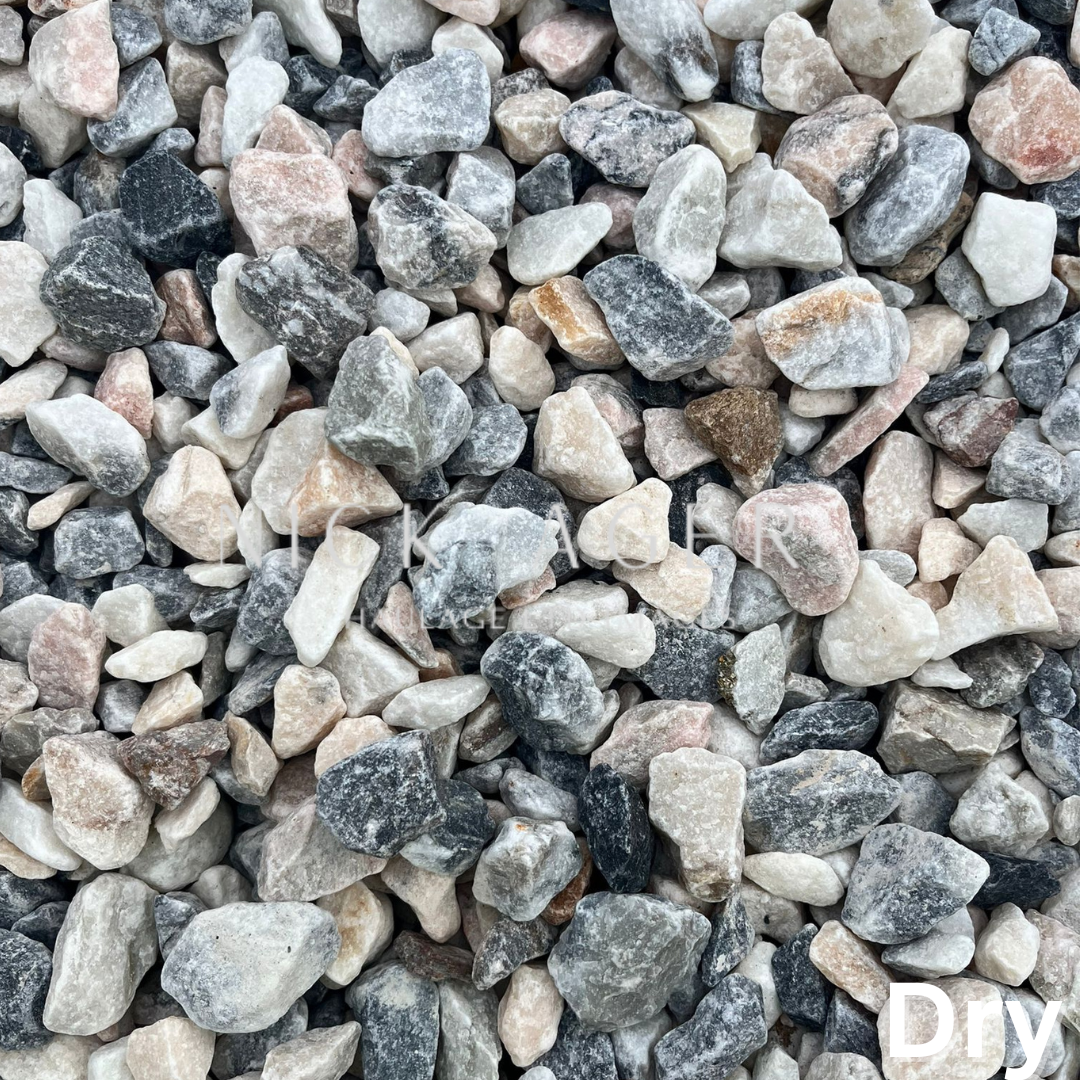 A close-up view of a mixture of small decorative gravel stones in shades of grey, pink, and white, suitable for landscaping.