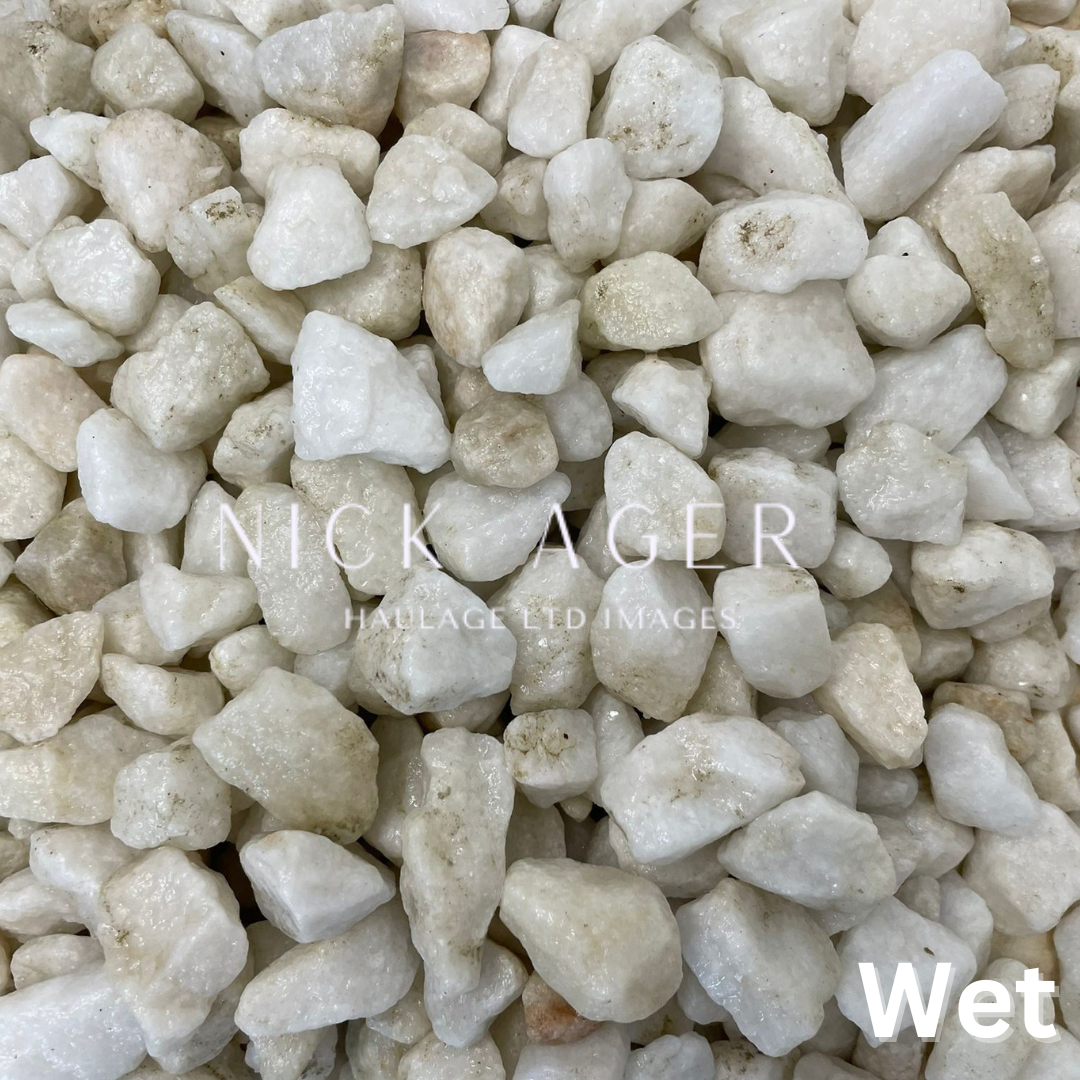 A close-up image of wet white pebbles of varying sizes, showcasing their smooth texture and natural colour variations.