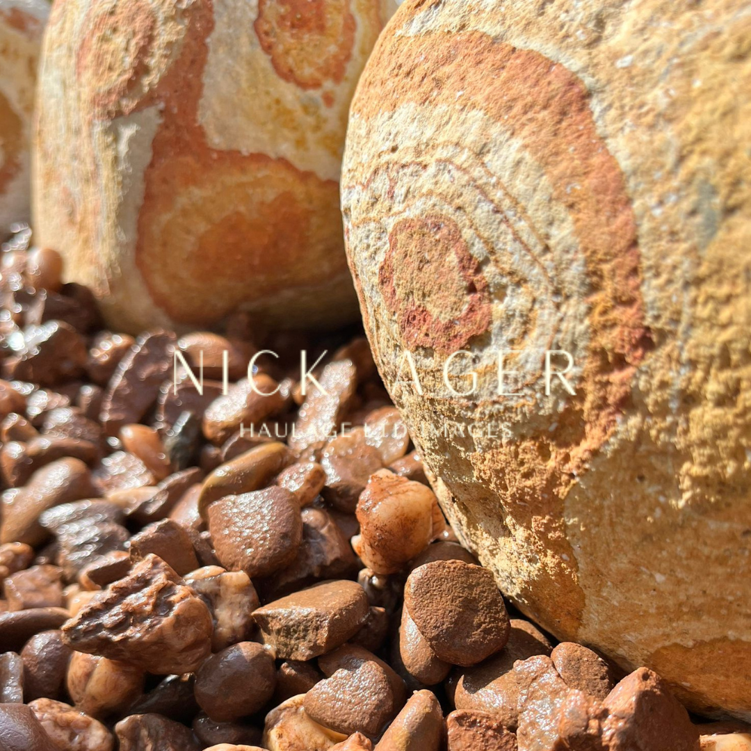 Close-up of textured stones with vibrant patterns resting on a bed of small pebbles.